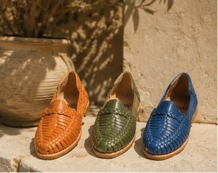 Tres huaraches camel, verde oliva y azul sobre una repisa de piedra
