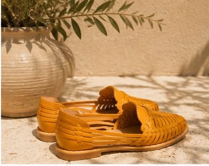 Huaraches color mostaza de perfil sobre una repisa de piedra