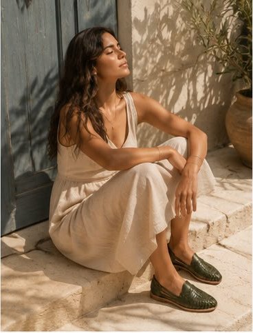 Modelo sentada en un escalón con huaraches verde oliva