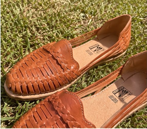 Detalle de huaraches cognac sobre césped