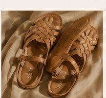Sandalias de piel trenzada fotografiadas sobre lino
